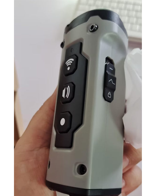Hand holding a remote control device with multiple buttons on a light background