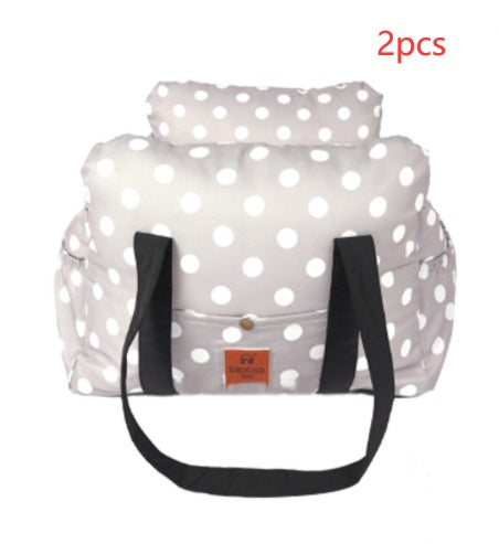 White polka dot bag with black straps on a white background