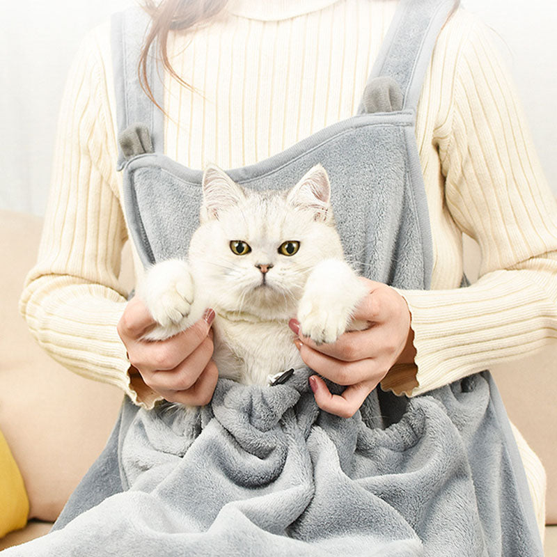 Person holding a white cat in a gray pet carrier