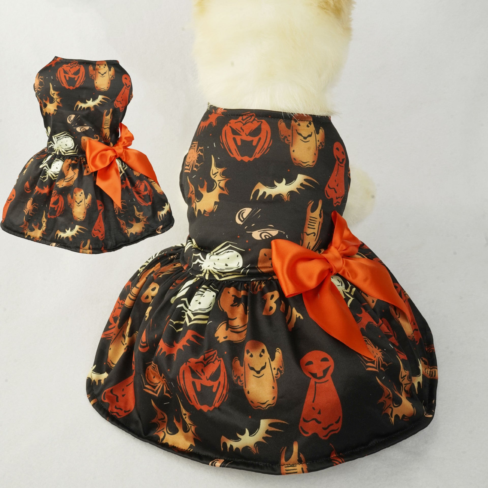 Halloween-themed dog dress with pumpkins, ghosts, and bats on a white background