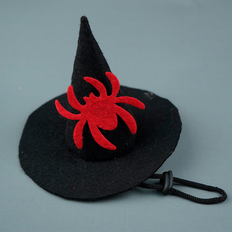 Black witch hat with a red spider design on a gray background