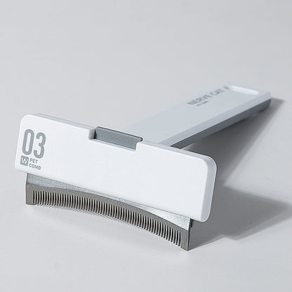Pet grooming comb with a white handle and metal teeth on a gray background