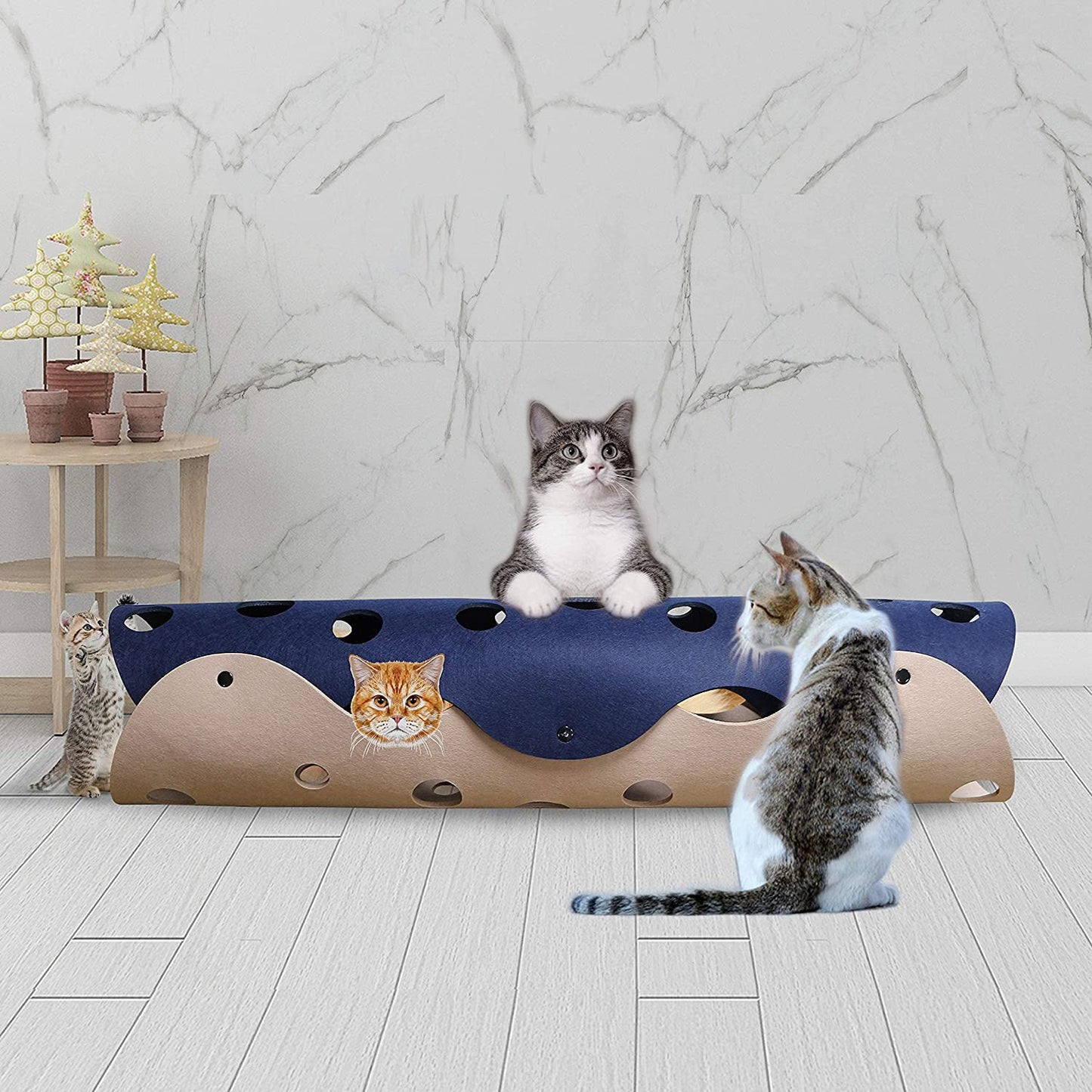 Cat playing with a blue and brown cat toy on a marble floor.
