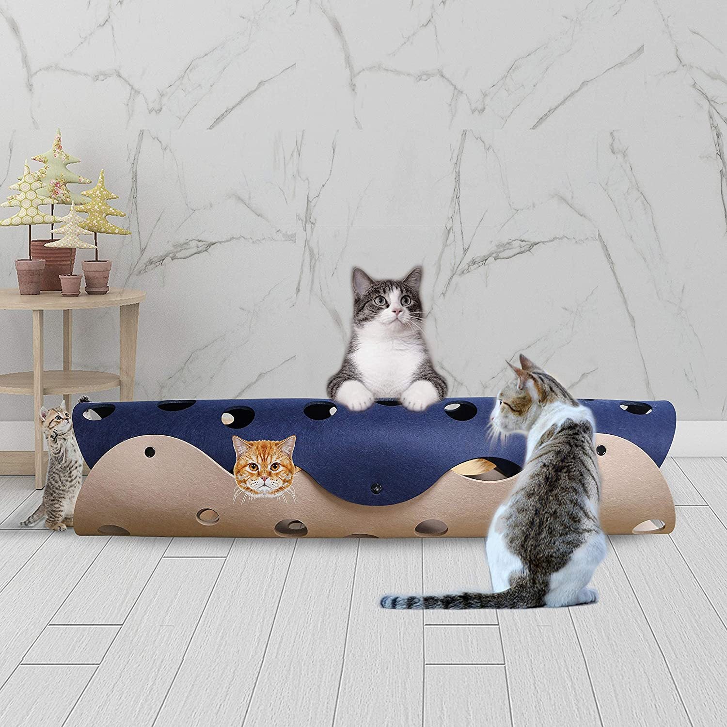 Cat playing with a blue and brown cat toy on a marble floor.