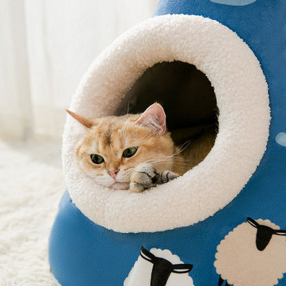 Cat peeking out from a blue and white pet house with cloud designs.