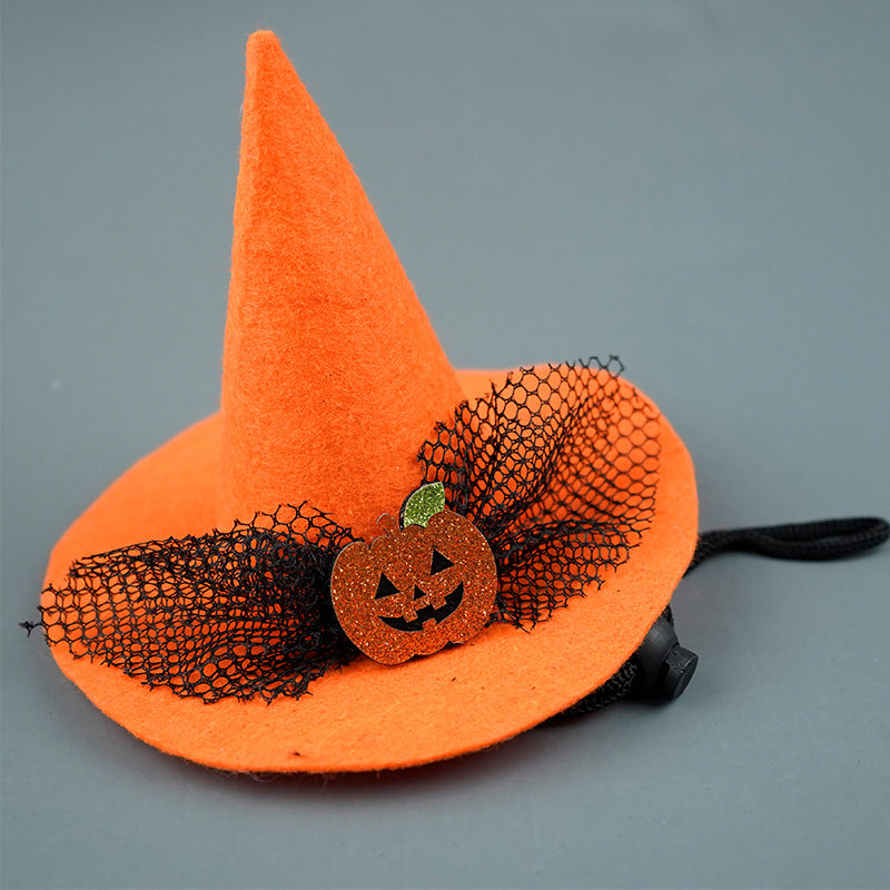Orange witch hat with black netting and pumpkin decoration on a gray background