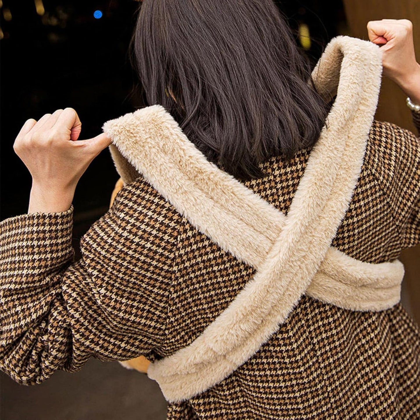 Person wearing a brown houndstooth coat with beige fur trim
