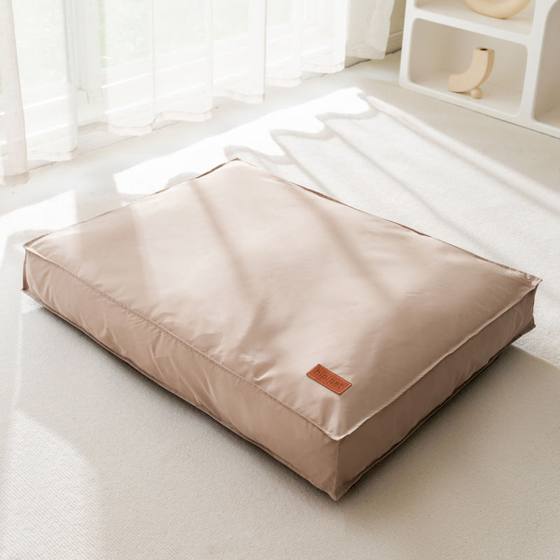 Beige pet bed on a white floor with a neutral background