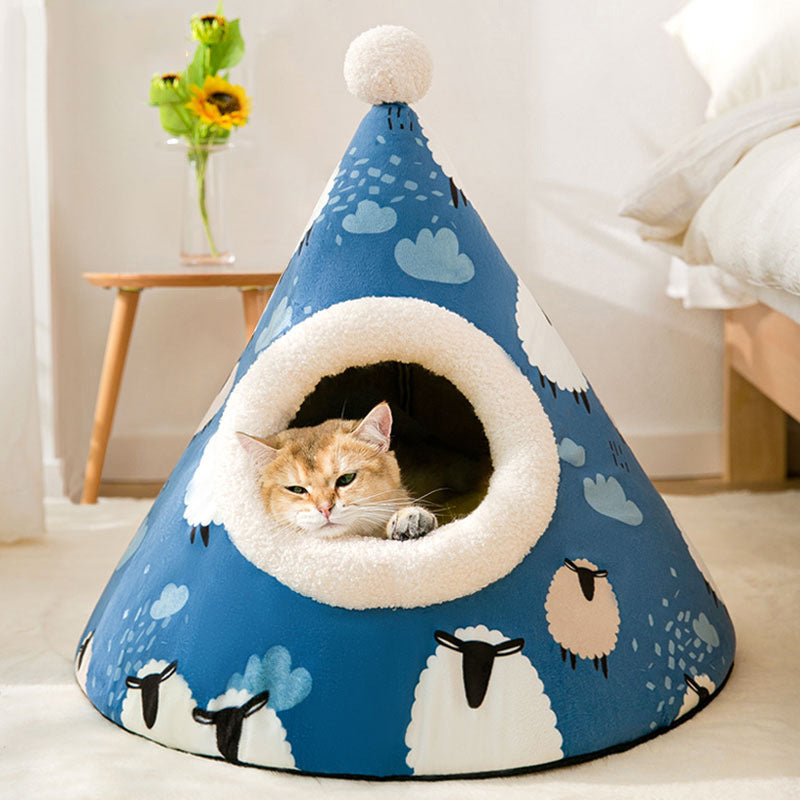 Blue pet bed with sheep pattern featuring a cat inside, placed on a light-colored floor.