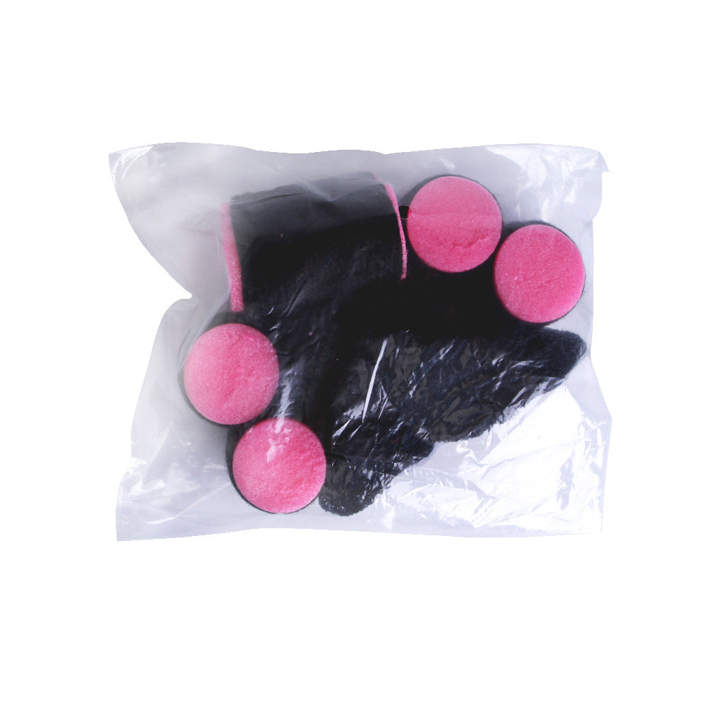 Black hair extensions with pink ends in a clear plastic bag on a white background