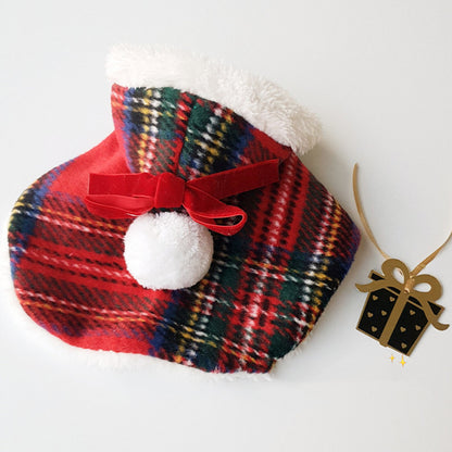 Plaid hot water bottle cover with red bow and white pom-pom on a white background
