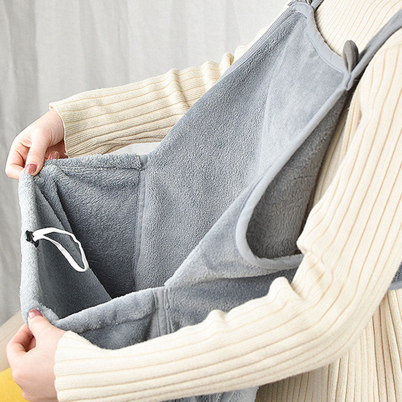 Person holding a gray pet hammock with a white curtain in the background
