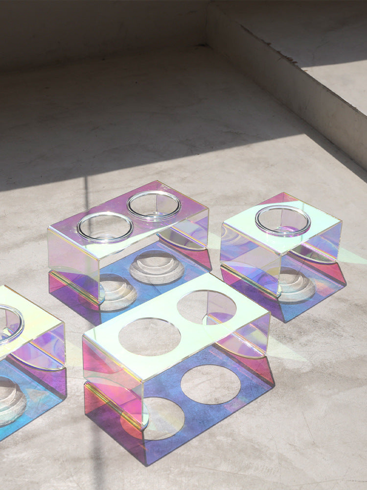 Iridescent geometric candle holders on a neutral background