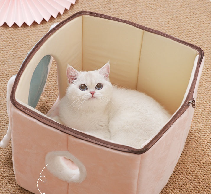 White cat sitting inside a beige pet bed on a carpeted floor.