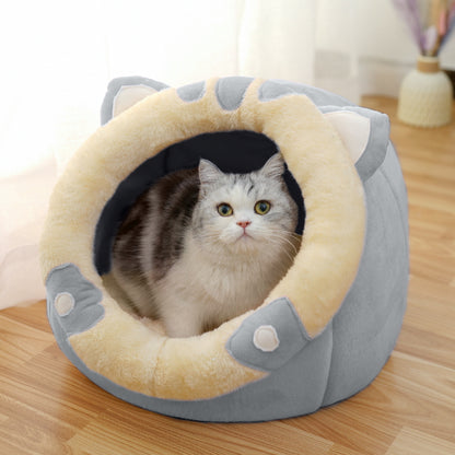 Cat sitting inside a round, plush pet bed with a beige interior and gray exterior on a wooden floor.