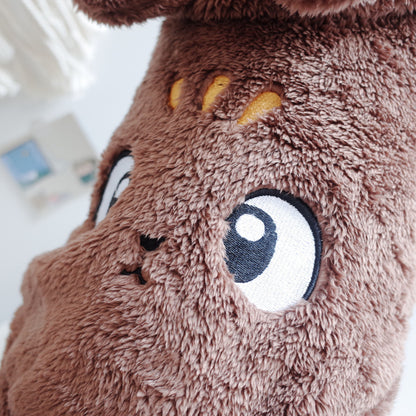 Close-up of a brown plush toy with large eyes and a blurred background