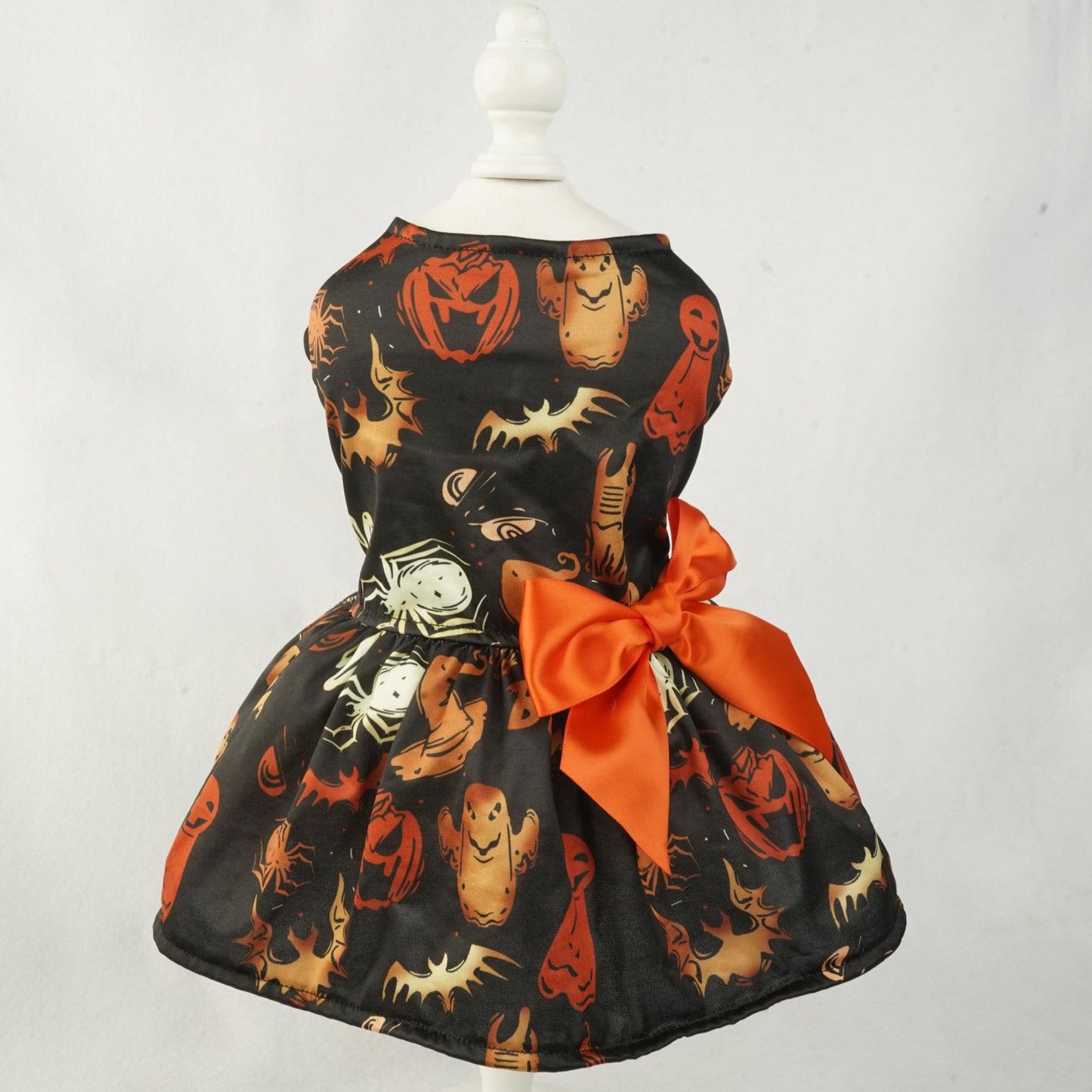 Halloween-themed pet dress with pumpkins, ghosts, and spiders on a mannequin against a white background.