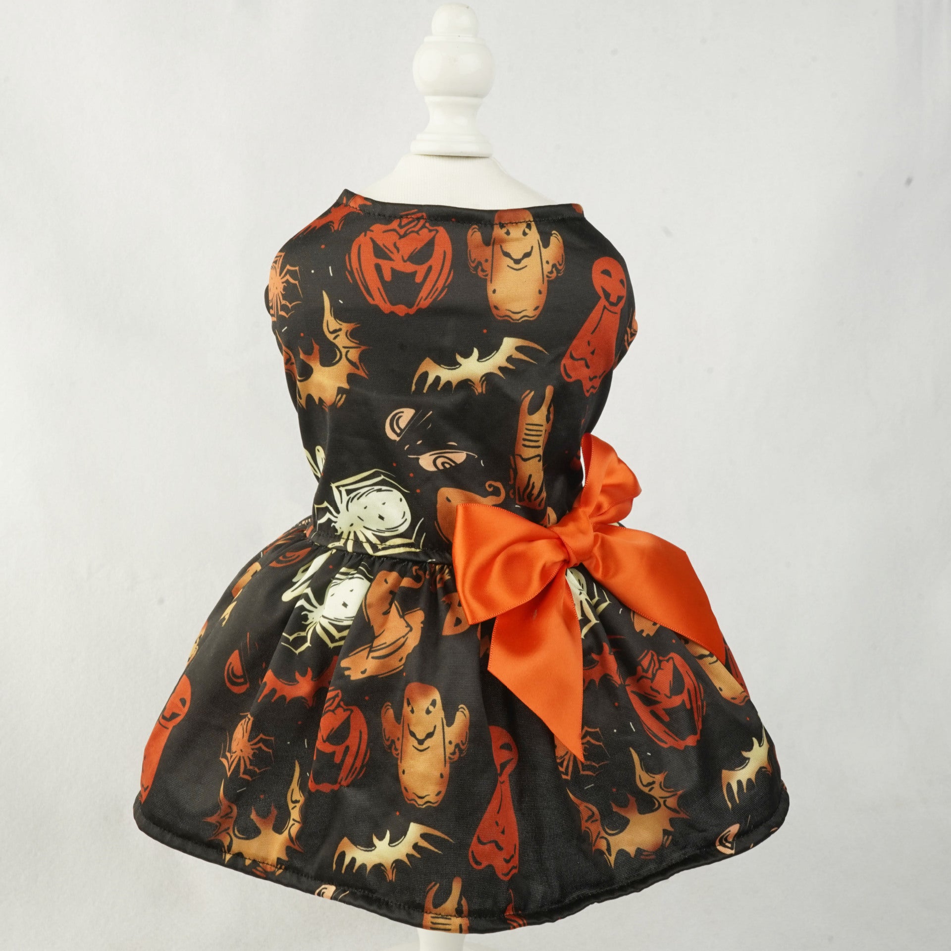 Halloween-themed pet dress with pumpkins, ghosts, and spiders on a mannequin against a white background.